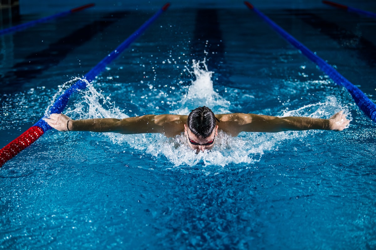 Swimmer doing laps in a public pool in Malaysia on a sunny day